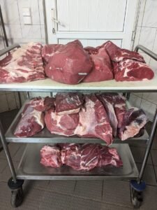 Rindfleisch-Teilstücke auf einem Gestellwagen im Kühlraum